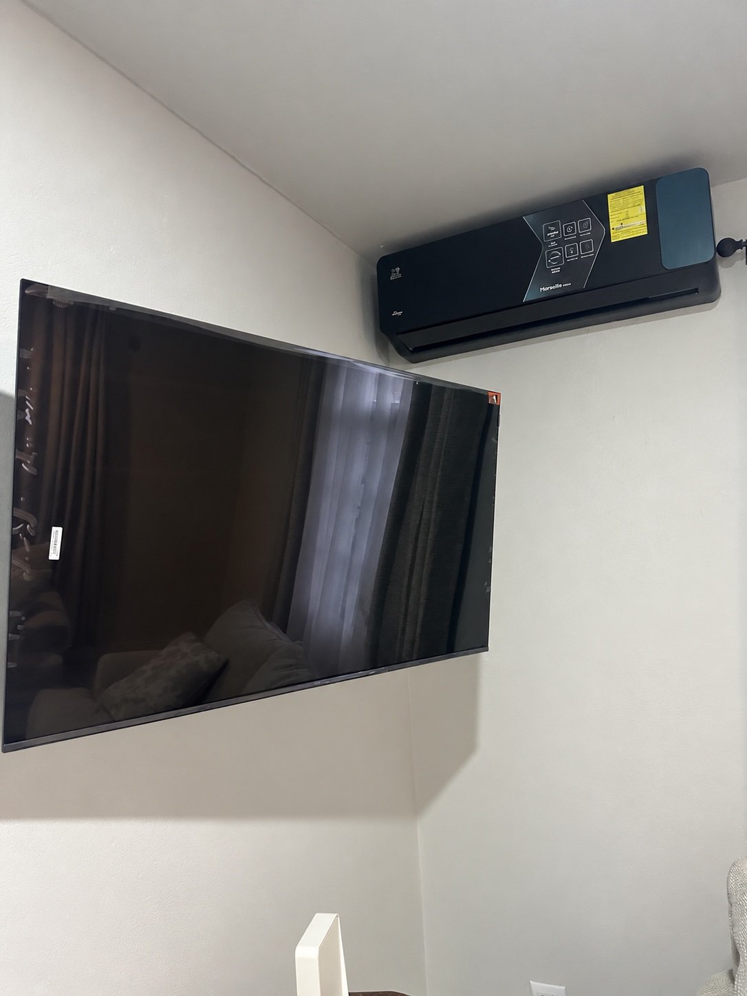 Wall-mounted television below a split-system air conditioner