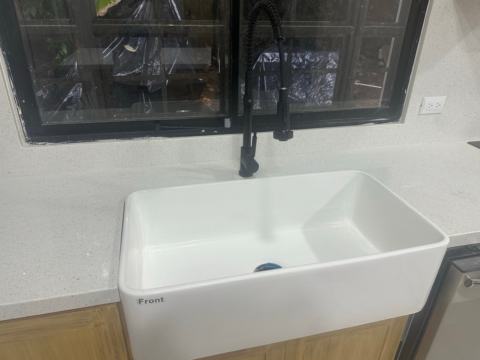 Deep kitchen sink below dark-framed window