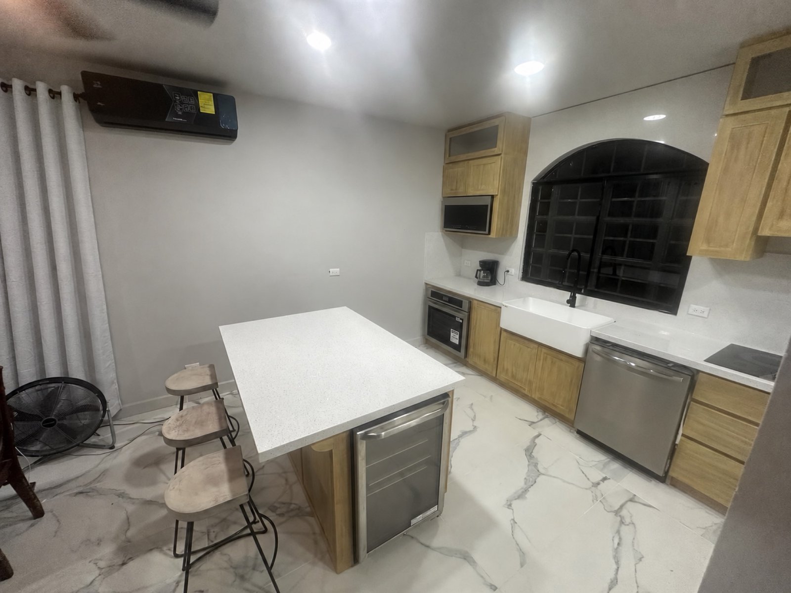 Remodeled kitchen with light counters and dark-framed window